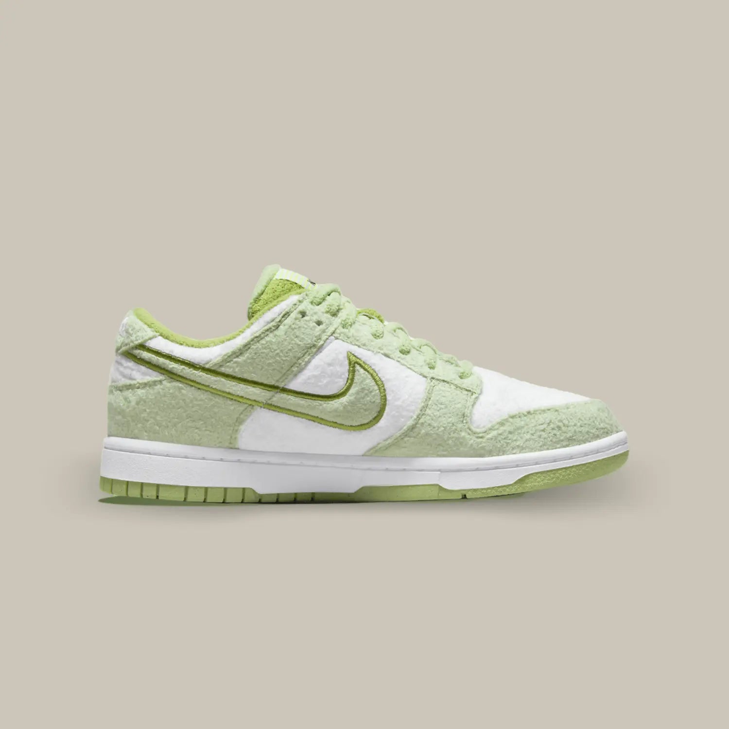 La Nike Dunk Low SE Fleece Green de coté avec une matière polaire qui recouvre l’ensemble de l’empeigne. Des empiècements vert melon s’associent aux parties blanches.