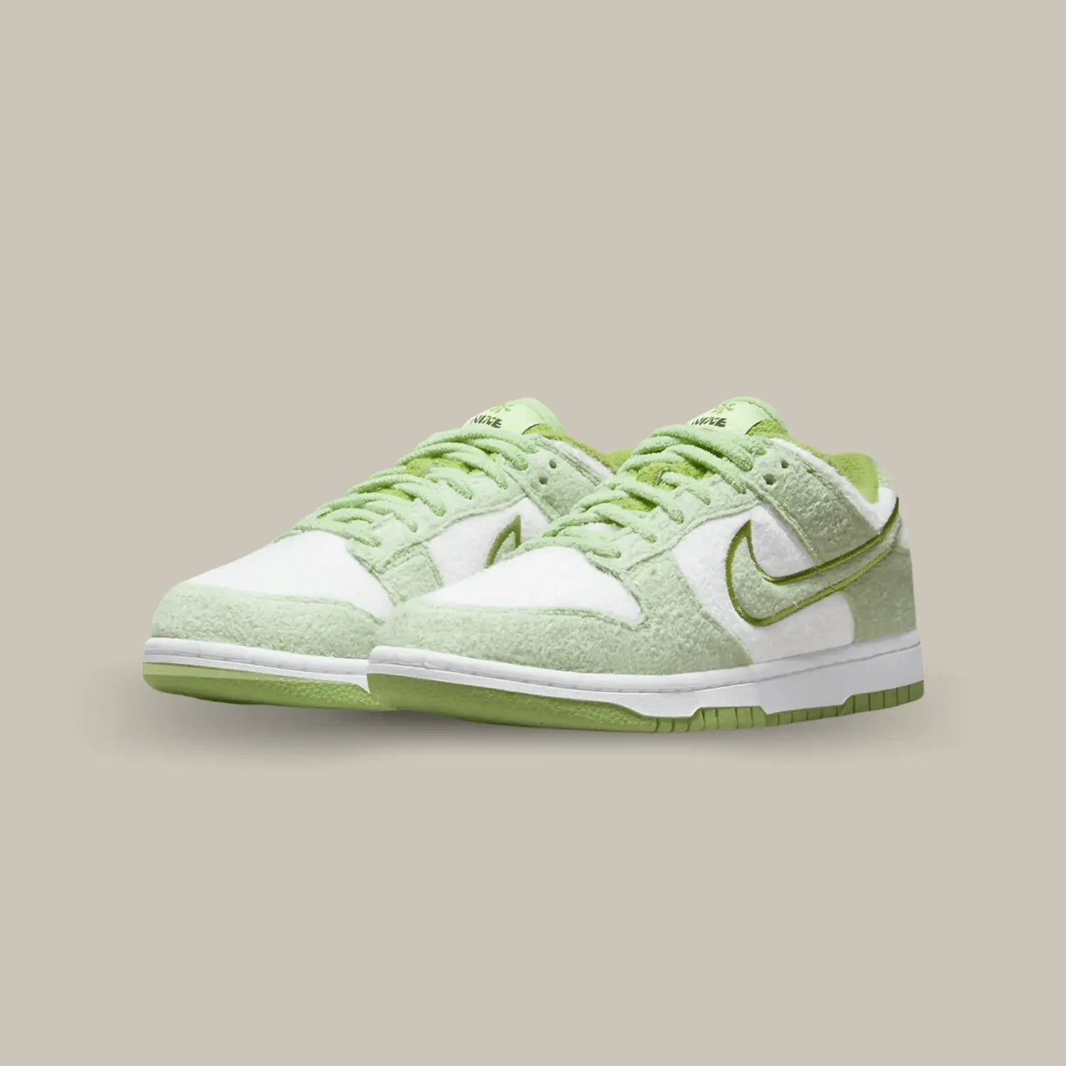 La Nike Dunk Low SE Fleece Green affiche une matière polaire qui recouvre l’ensemble de l’empeigne. Des empiècements vert melon s’associent aux parties blanches.
