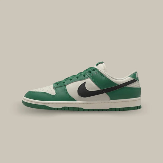 La Nike Dunk Low SE Lottery Green Pale Ivory de coté avec sa base en cuir blanc cassé qui s’accompagne de superpositions en cuir vert bouteille.