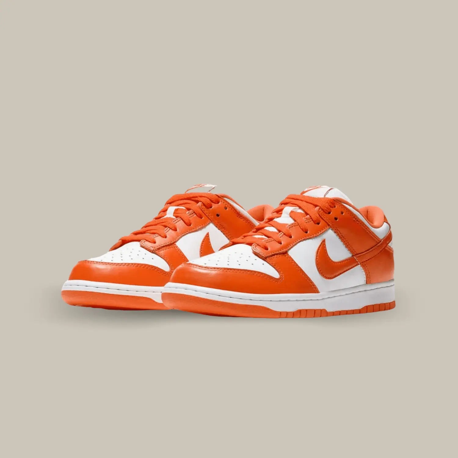 La Nike Dunk Low Syracuse se pare d’une empeigne en cuir blanc sublimée par des empiècements orange, reprenant les couleurs de l’équipe universitaire de Syracuse. On note des lacets orange assortis, ainsi qu’un branding Nike sur le talon ainsi que sur la languette.