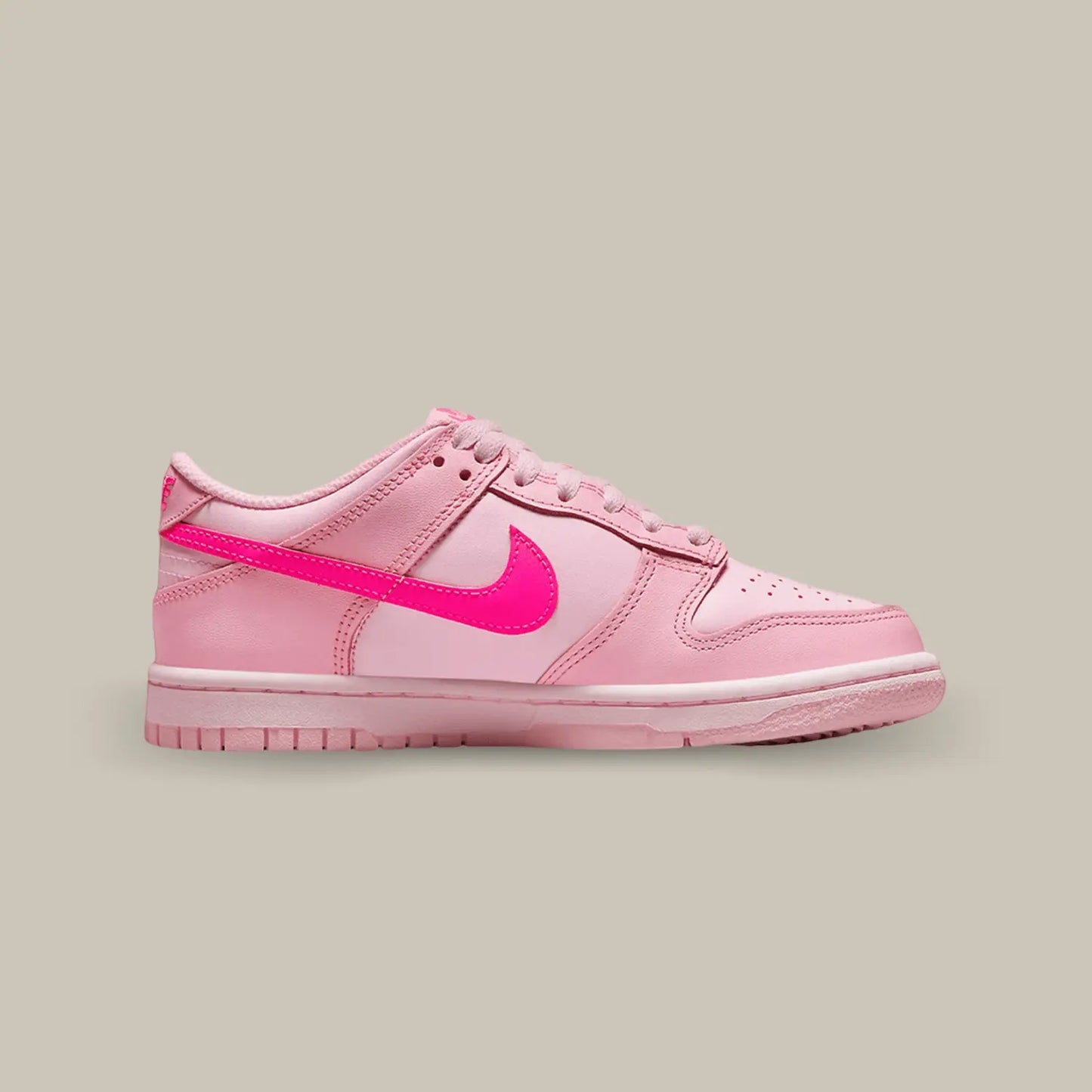 La Nike Dunk Low Triple Pink de coté avec une base de rose clair, des empiècement rose foncé et le swoosh rose pétante.