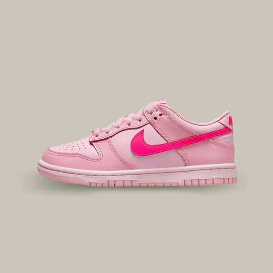 La Nike Dunk Low Triple Pink de coté avec une base de rose clair, des empiècement rose foncé et le swoosh rose pétante.