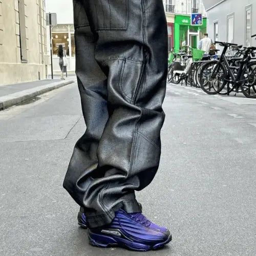 La Nike Hot Step 2 Drake NOCTA Eggplant portée avec un baggy noir brillant.