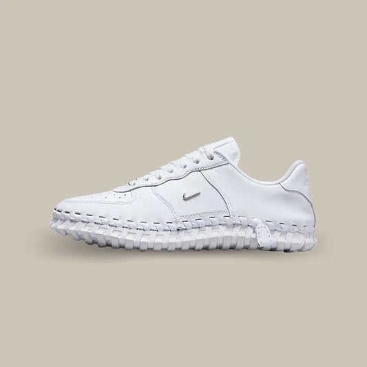 La Nike J Force 1 Low Jacquemus White de coté avec une base en cuir blanc et en mesh accompagnée d’une semelle tressée.