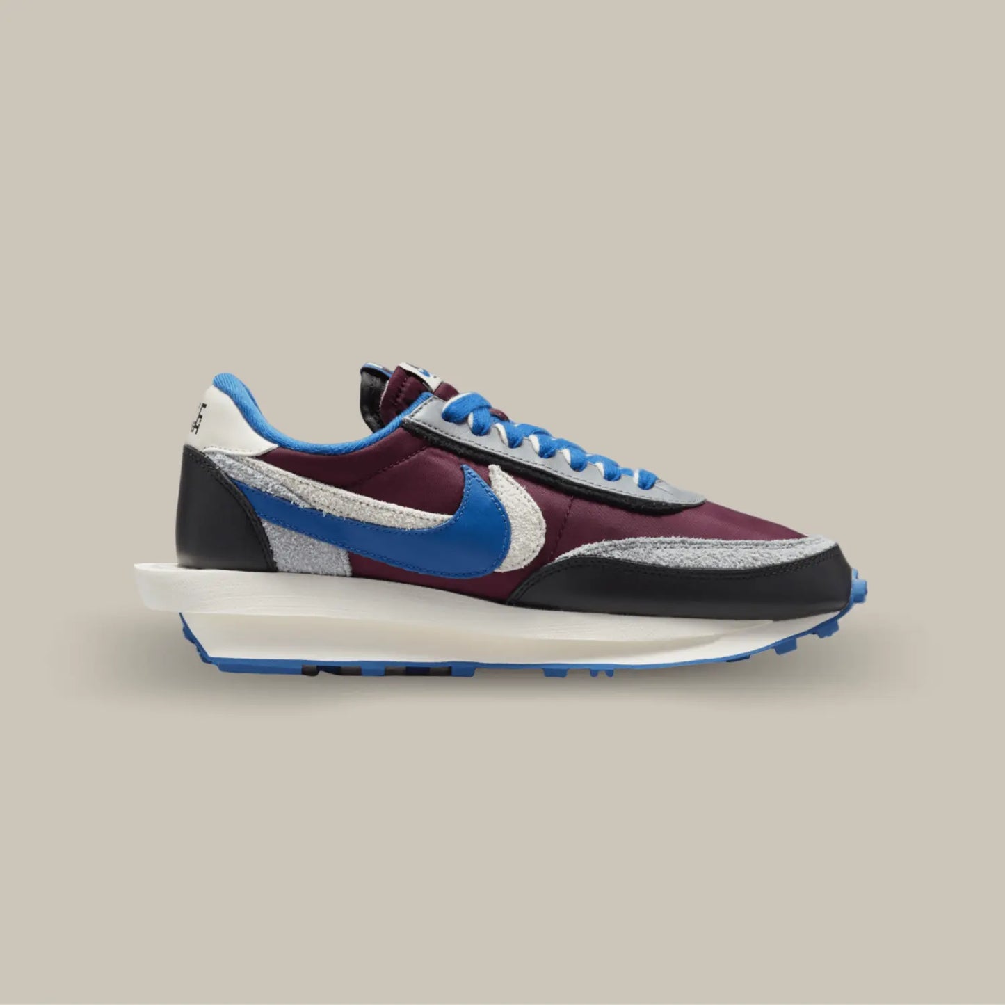 La Nike LD Waffle Sacai Undercover Night Maroon Team Royal de coté avec ses couleurs bleu et bordeaux avec quelques touches de noir, blanc et gris. On retrouve deux swoosh superposé de couleur bleu et blanc.