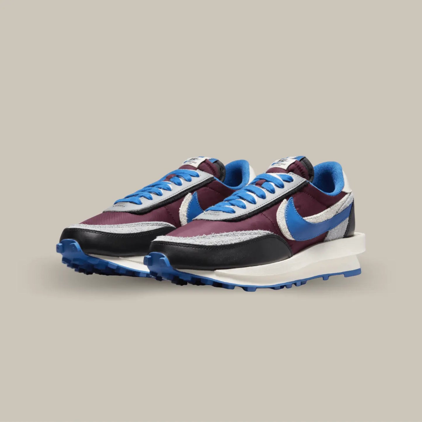 La Nike LD Waffle Sacai Undercover Night Maroon Team Royal possède une base en nylon avec des touches de suède à poils longs et quelques empiècements en cuir lisse. On retrouve sur cette paire unique une palette de couleurs entre le bleu et le bordeaux avec quelques touches de noir, blanc et gris.