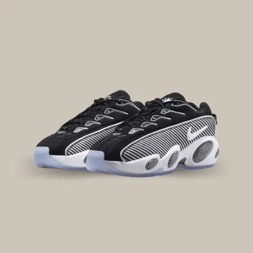 La Nike NOCTA Glide Black White possède une base en mesh noir avec un empiècement à rayures grises et noires prenant tout le long de la chaussure et incorporant un mini swoosh blanc. On retrouve quatre "bug eyes" sur l'imposante semelle qui font penser à la Nike Zoom Flight 85.