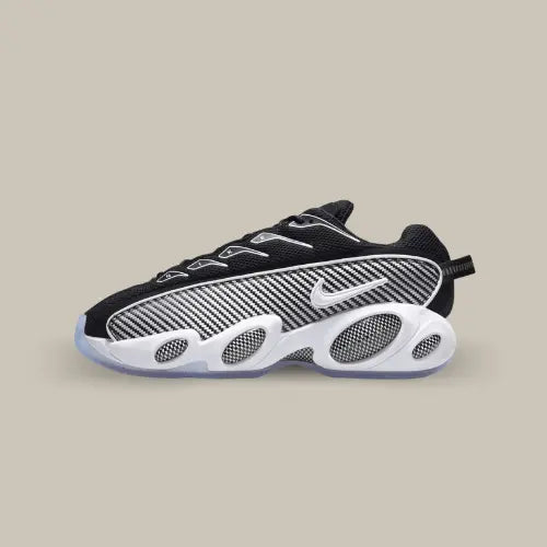 La Nike NOCTA Glide Black White de côté avec son coloris noir, son empiècements composé de rayures grises et noires et ses quatre eyes bug situés sur la semelle blanche imposante. 