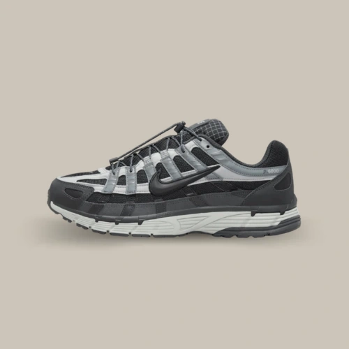 Image 1 : Nike P-6000 Anthracite Smoke Grey noire et grise avec empiècements réfléchissants et laçage à cordon, vue de profil sur fond beige. Disponible sur Offsneakz.