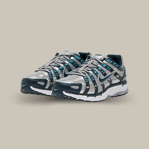 Paire de Nike P-6000 Armory Navy bleu marine et argentée avec détails turquoise, vue de trois quarts sur fond beige. Disponible sur Offsneakz.