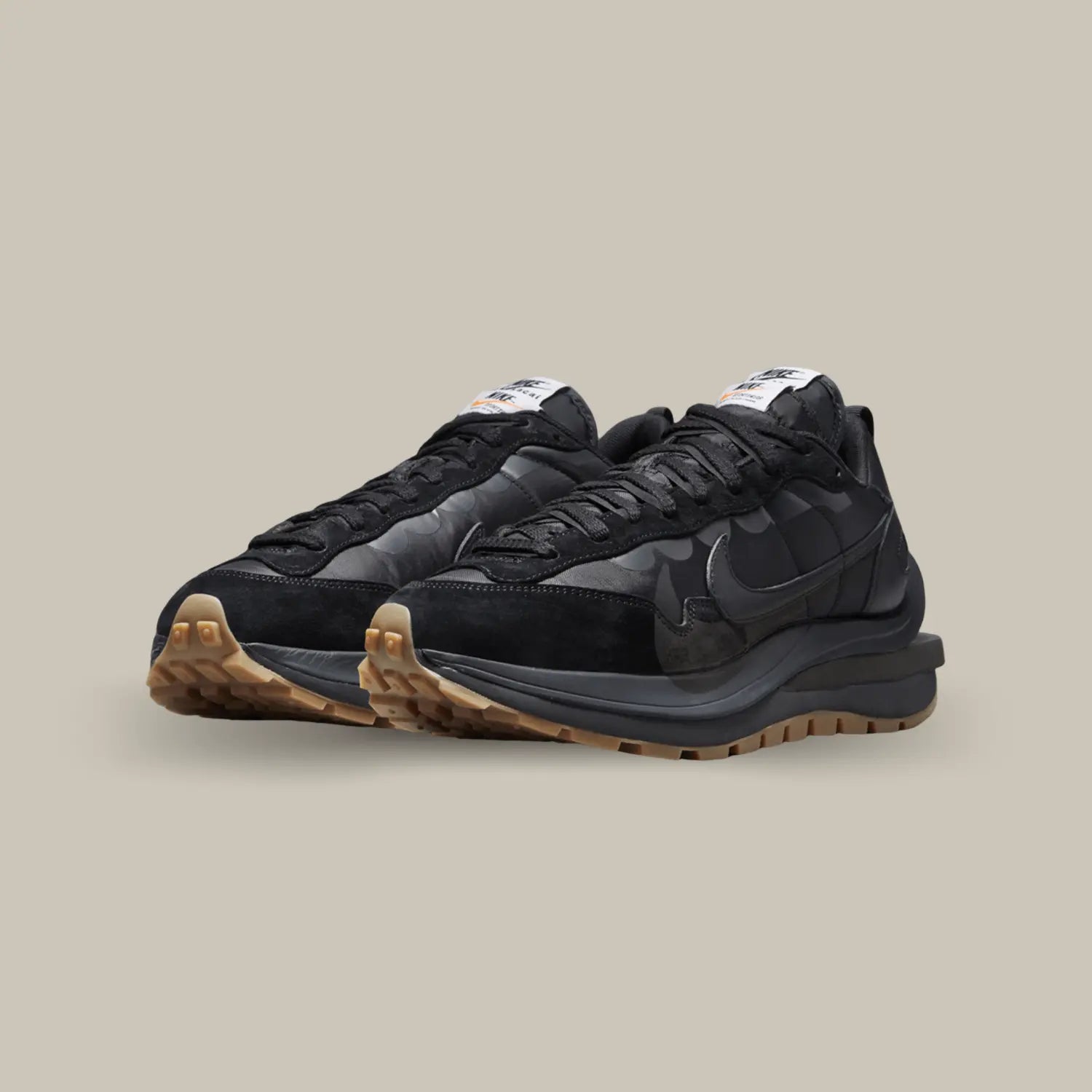 La Nike Vaporwaffle Sacai Black Gum propose un design composé de superpositions de matières et d’éléments dédoublés. Elle se pare d’un upper en suède et tissu nylon, le même matériau que l’on a pu retrouver sur les LD Waffle Triple Black et White. Chacun des éléments est présenté en noir et s’accorde à la midsole. Pour créer un léger contraste, l’outsole opte quant à elle pour du gum.