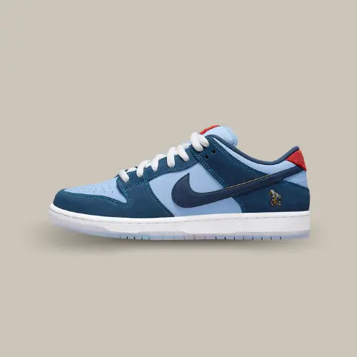 La Nike SB Dunk Low Pro Why So Sad? vue de côté avec sa base en su-de bleu clair et ses empiècement bleu foncé.