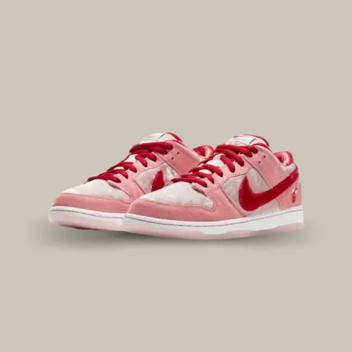 La Nike SB Dunk Low StrangeLove s'inspire de la fête des amoureux avec une empeigne blanche et rouge en velours accompagnées d'empiècements en velours rose. Les lacets et le swoosh font un rappel de rouge pour le côté amour que l'on retrouve également avec le motif tête de mort en forme de cœur sur le talon.