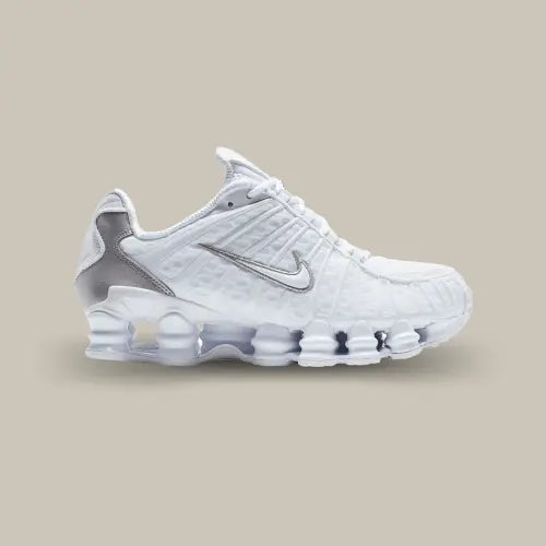 La Nike Shox TL White Metallic Silver vue de côté avec sa base blanche et ses touches de gris au niveau du swoosh et du talon. On retrouve la semelle comportant le système Shox sur toute la semellle.