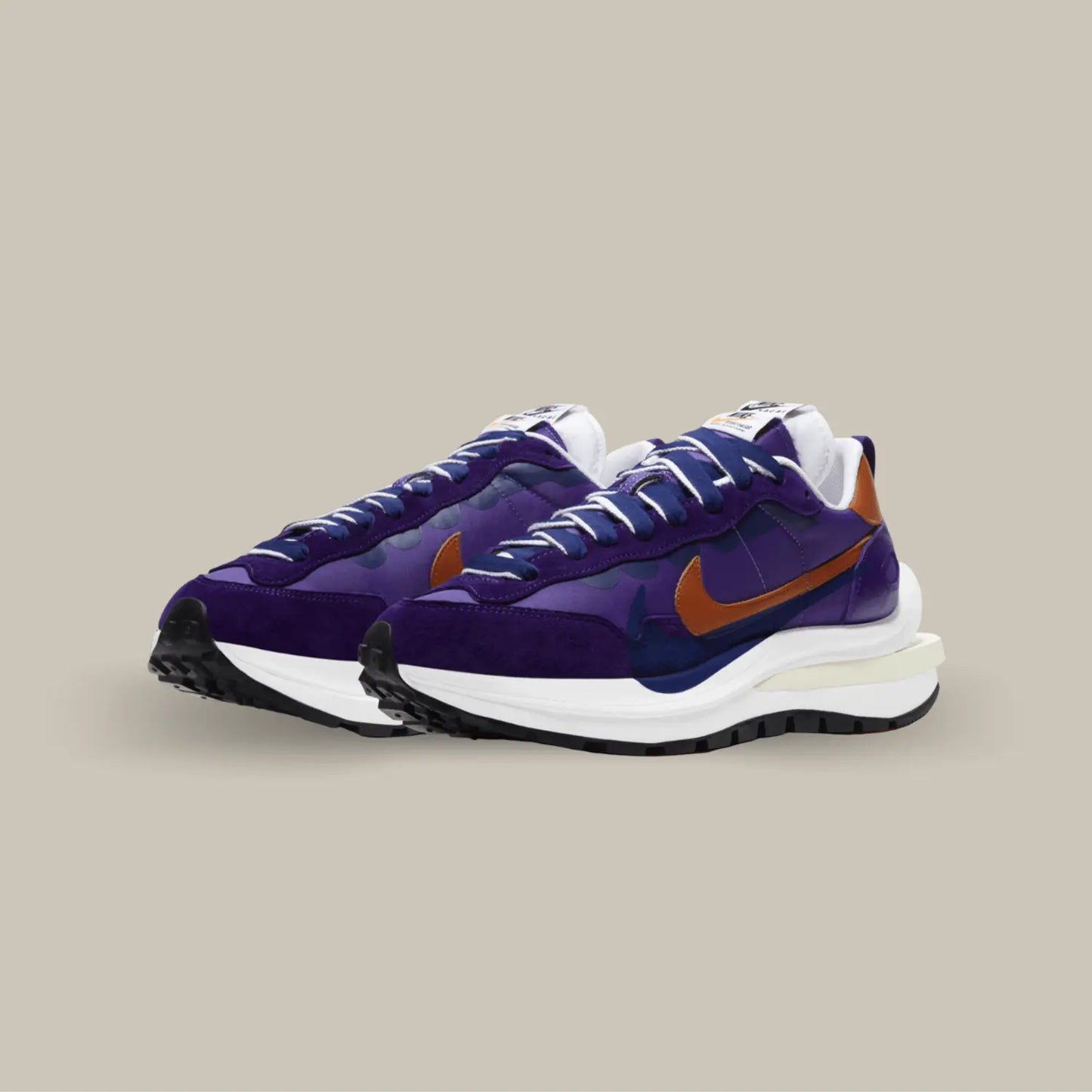 La Nike Vaporwaffle Sacai Dark Iris possède une tige en nylon violet avec des empiècements en daim dans un mélange de nuances violettes profondes et de nuances bleu nuit. On trouve un swoosh marron accordé au heel tab qui contrastent avec le tout.