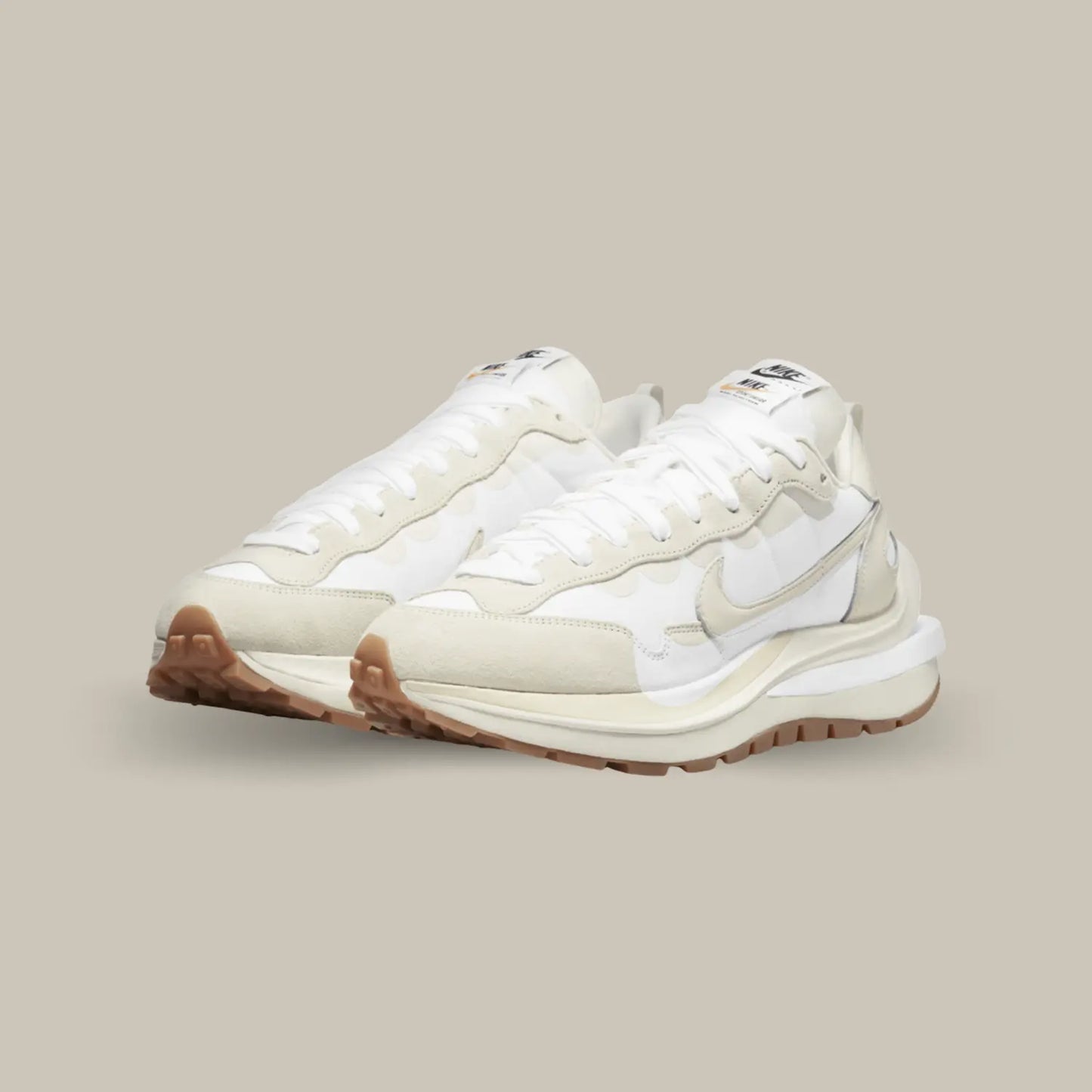 La Nike Vaporwaffle Sacai Sail Gum propose un design composé de superpositions de matières et d’éléments dédoublés. Le upper joue sur une palette de couleurs très proches les unes des autres avec du blanc et blanc cassé, ce qui donne une allure élégante et sophistiquée à cette itération.