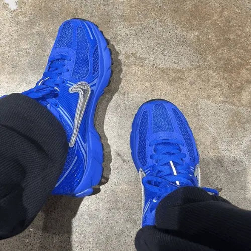 La Nike Zoom Vomero 5 Racer Blue portée avec un pantalon noir.