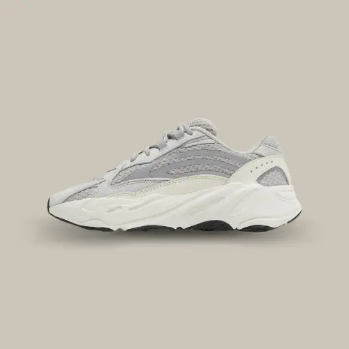 Parée d'un upper aplani, la Yeezy 700v2 est couverte d'une toile en maille grise "Static" avec une finition en cuir. Les trois célèbres bandes de la marque allemande sont apposé sur un matériau réfléchissant. Ce modèle est composé d'un mélange de couleurs avec du crème, du gris clair, de l'argent et une semelle en caoutchouc noir.