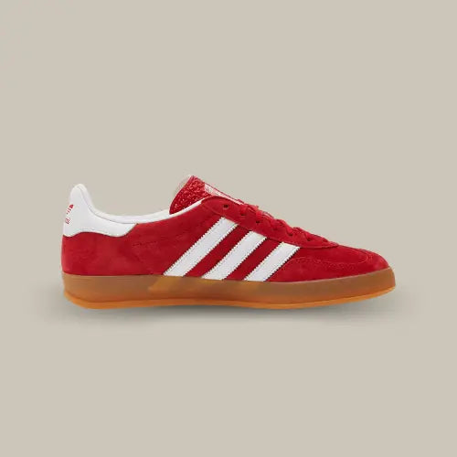 La Adidas Gazelle Indoor Scarlet Cloud White de coté avec son suède rouge, ses trois bandes en cuir blanc et sa semelle en gomme de caoutchouc.