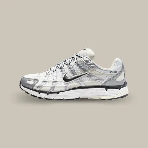 La Nike P-6000 Coconut Milk Metallic Silver vue de côté avec sa base en mesh blanc et ses superpositions en cuir argentées.