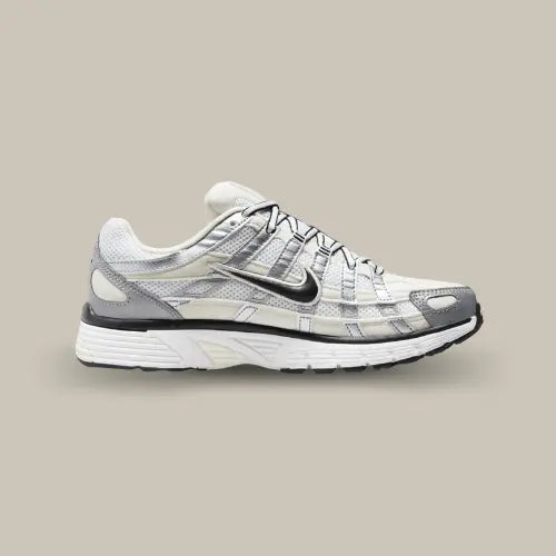 La Nike P-6000 Coconut Milk Metallic Silver vue de côté avec sa base en mesh blanc et ses superpositions en cuir argentées.