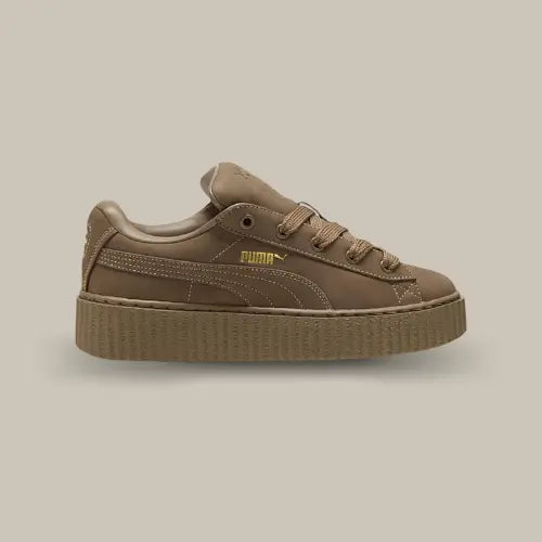 La Puma Creeper Phatty Rihanna Fenty Totally Taupe vue de côté avec s tige de couleur taupe et la bande puma ton sur ton. On retrouv le logo Puma en doré pour un petit côté luxueux.