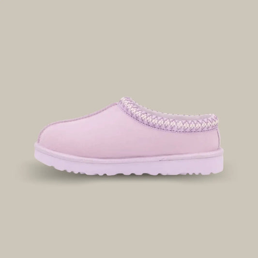 La Ugg Tasman Slipper Lavender Fog de coté avec sa tige en daim rose pâle, son tressage en polyester recyclé gris et blanc et sa semelle en EVA.